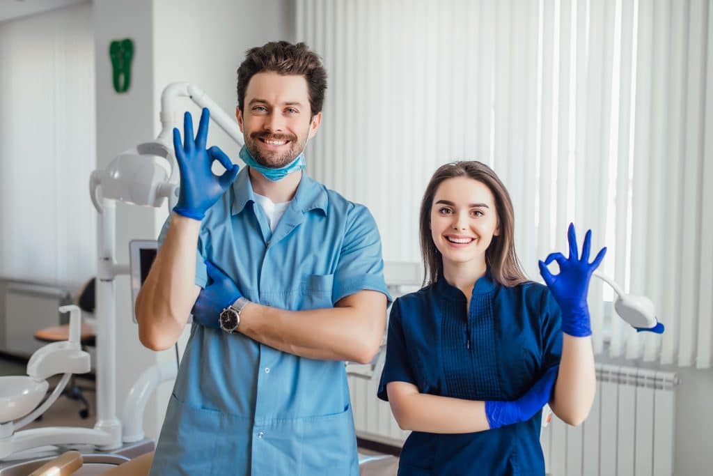 two dentists are showing thumbs up