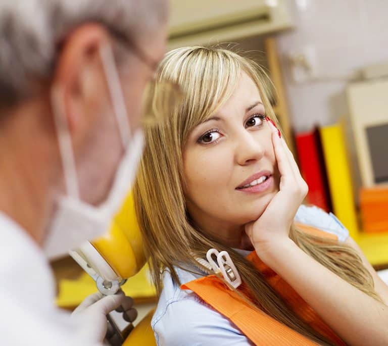 a lady is having pain and visits clinic for root canal treatment